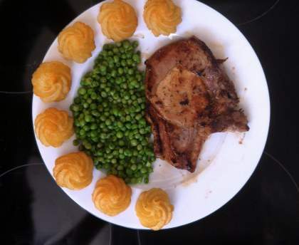 Côtes de porc, pommes duchesses et petits pois étuvés