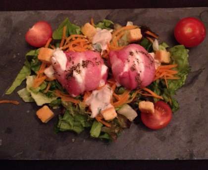Petits chèvres chauds bardés de lard sur lit de roquette