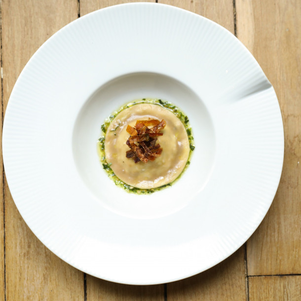 Ravioli farci de légumes passés et fromage maison, bouillon de langoustines et chips d'épluchures